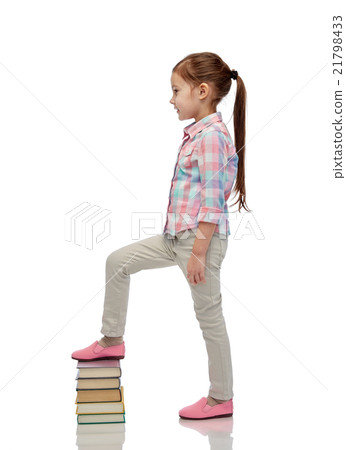 happy little girl stepping on book pile happy little girl stepping on book pile 21798433