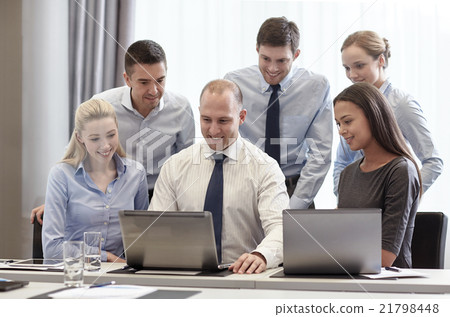 smiling businesspeople with laptops in office smiling businesspeople with laptops in office 21798448