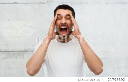 crazy shouting man in t-shirt over gray wall 21798892