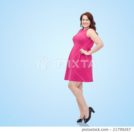 happy young plus size woman posing in pink dress 21799267