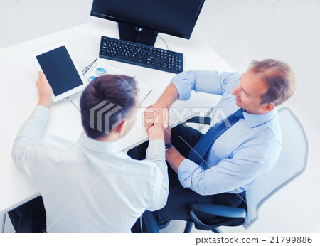 businessmen shaking hands in office 21799886