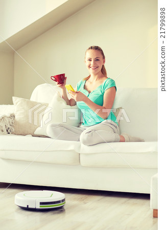 happy woman with smartphone drinking tea at home happy woman with smartphone drinking tea at home 21799898