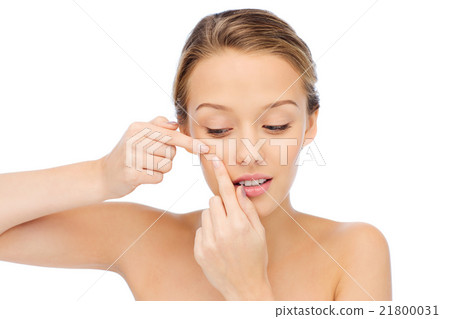 young woman squeezing pimple on her face young woman squeezing pimple on her face 21800031
