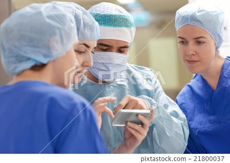 group of surgeons with smartphone at hospital 21800037