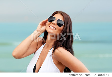 smiling young woman with sunglasses on beach smiling young woman with sunglasses on beach 21800157