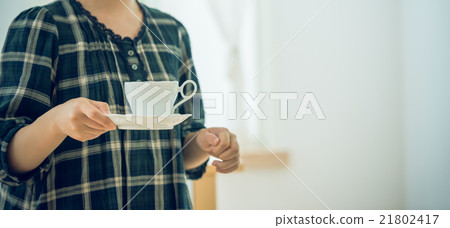 一位女士手捧咖啡杯,享受著輕鬆的時光。 一位女士手捧咖啡杯,享受著輕鬆的時光。 21802417