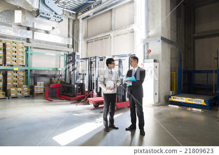 Two men in work wear clothes and suit in business image warehouse Two men in work wear clothes and suit in business image warehouse 21809623