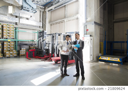 Two men in work wear clothes and suit in business image warehouse Two men in work wear clothes and suit in business image warehouse 21809624