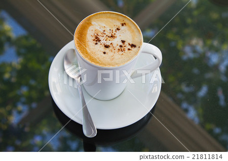 A cup of coffee in a white cup on glass background 21811814