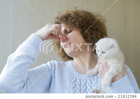 woman with allergy is holding kitten woman with allergy is holding kitten 21812394
