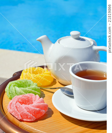 Cup of tea on a saucer, teapot and marmalade 21819866