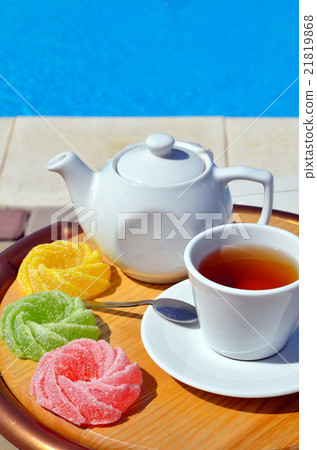 Cup of tea with a teapot and colored marmalade 21819868
