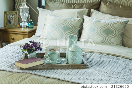Decorative tray with book and tea set on the bed 21826630