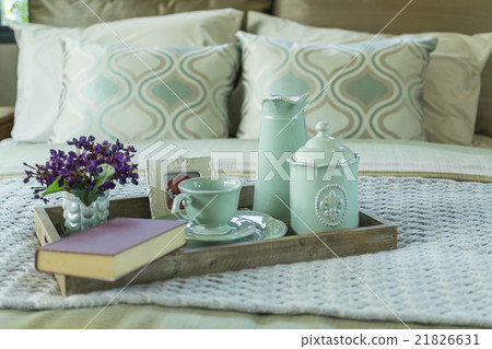 Decorative tray with book and tea set on the bed 21826631