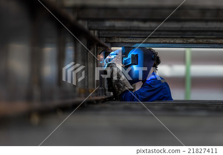 Worker with protective mask welding metal 21827411