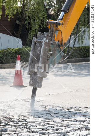 Excavator breaking concrete road for repairing 21834145