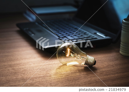 light bulb on wooden table with laptop 21834979