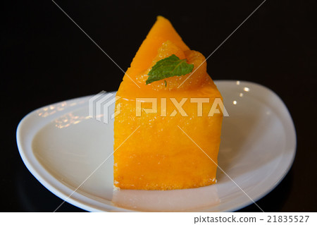 orange cake with orange topping in white dish 21835527