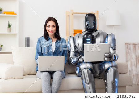 Positive girl and robot using laptops Positive girl and robot using laptops 21839082