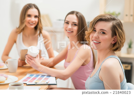 Delighted girls sitting at the table 21840023
