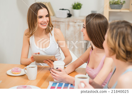 Positive girls sitting at the table Positive girls sitting at the table 21840025