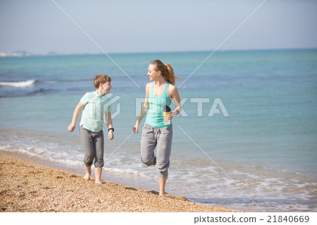Mother with son running on the beach Mother with son running on the beach 21840669