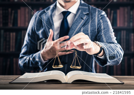 A man holding a balance, a heavy book A man holding a balance, a heavy book 21841595