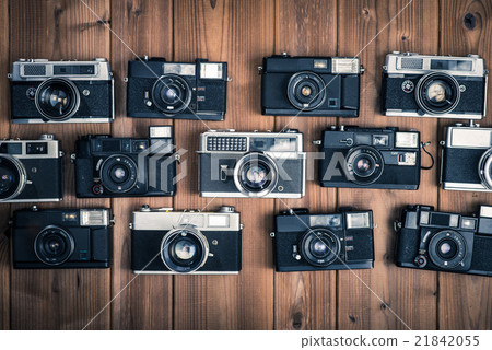 Old camera, single lens reflex, film camera placed on a wooden table, bird's eye view shooting Old camera, single lens reflex, film camera placed on a wooden table, bird's eye view shooting 21842055