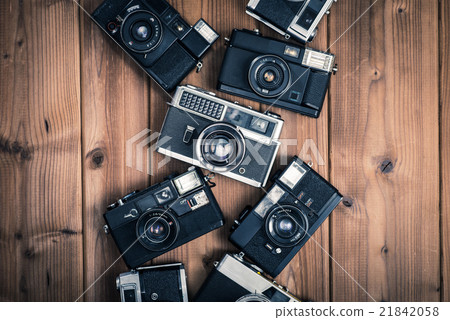 Old camera, single lens reflex, film camera placed on a wooden table, bird's eye view shooting 21842058