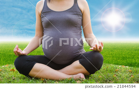 Healthy pregnant woman doing yoga in the meadow Healthy pregnant woman doing yoga in the meadow 21844594