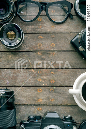 Old cameras and lens on wooden table, top view Old cameras and lens on wooden table, top view 21844802