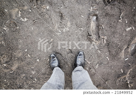 Male feet in new shoes stand on dirty rural road 21849952
