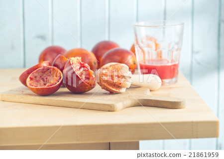 halved blood orange and juicer 21861959