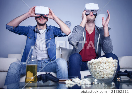 Cheerful friends are watching modern headset Cheerful friends are watching modern headset 21862311