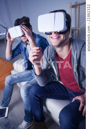Two guys are entertaining with modern technology Two guys are entertaining with modern technology 21862312