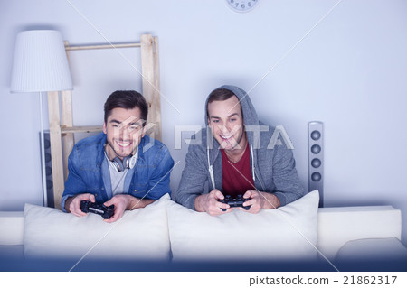 Attractive two guys are playing video games Attractive two guys are playing video games 21862317