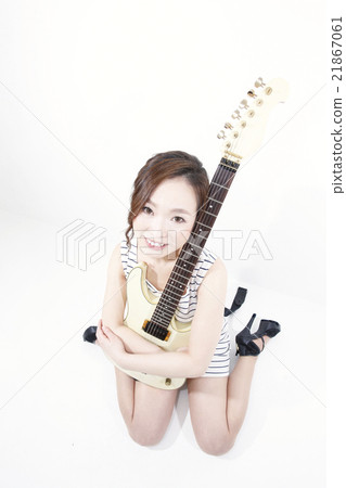 A woman holding a guitar A woman holding a guitar 21867061