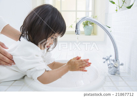 A 2 year old girl washing his hands 21867712