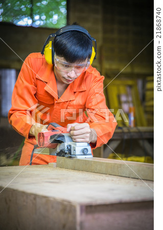 Carpenter working with plane on wooden background Carpenter working with plane on wooden background 21868740