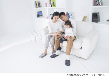 在生活方式沙發上操作智能手機的三個家庭 在生活方式沙發上操作智能手機的三個家庭 21870480