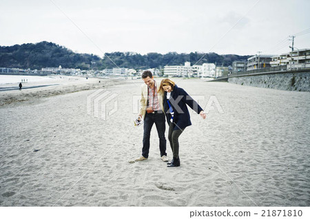 Foreign tourists walking along the beach Foreign tourists walking along the beach 21871810