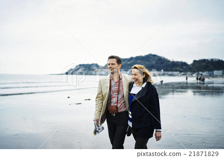 Foreign tourists walking along the beach Foreign tourists walking along the beach 21871829
