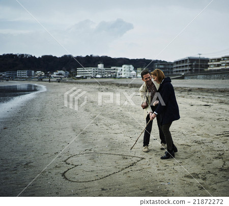 Foreign tourists walking along the beach Foreign tourists walking along the beach 21872272