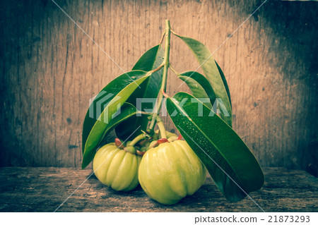 Fresh garcinia on wooden background. Vintage tone. 21873293