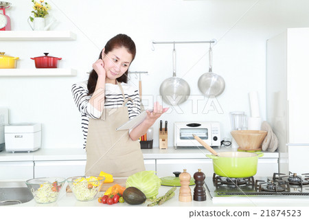 50s housewife who stands in the kitchen with a tablet 50s housewife who stands in the kitchen with a tablet 21874523