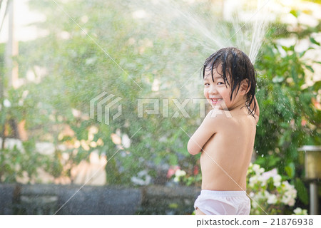 asian boy has fun playing in water from a hose asian boy has fun playing in water from a hose 21876938
