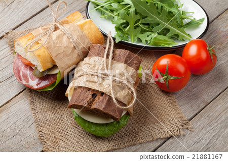 Two sandwiches with salad, ham, cheese  21881167