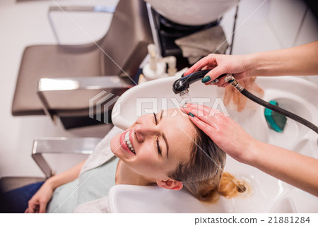 Unrecognizable professional hairdresser washing Unrecognizable professional hairdresser washing 21881284