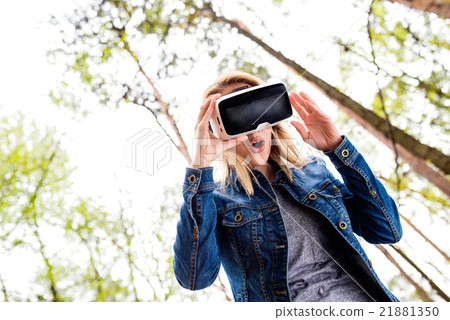 Woman wearing virtual reality goggles outside in 21881350