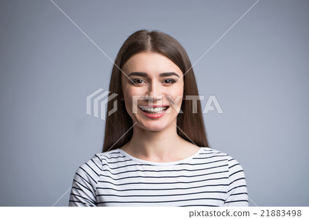 Positive girl standing isolated on grey background Positive girl standing isolated on grey background 21883498